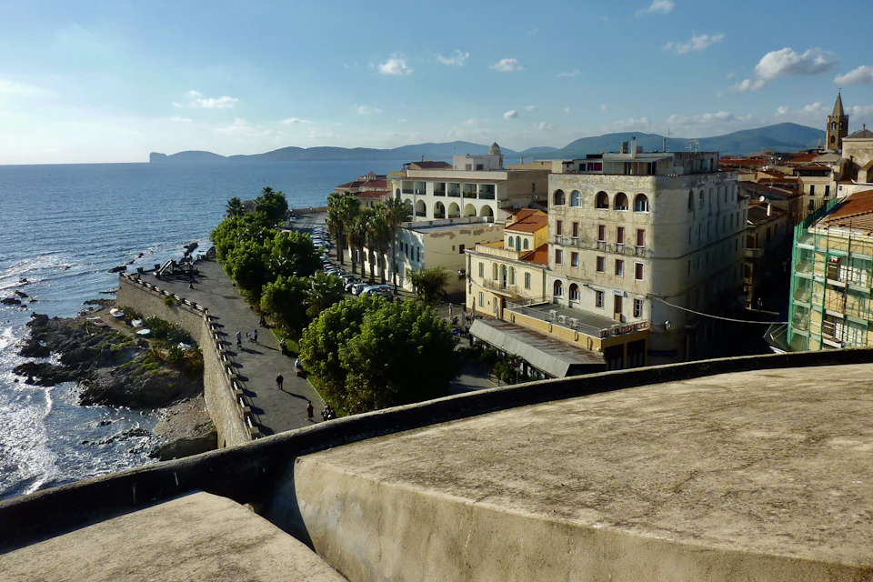 Case e lungomare con palme affacciati sul mare, visti dall'alto, ad Alghero