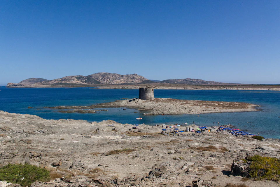 La spiaggia della Pelosa con la torre sull'isolotto e il mare basso e turchese